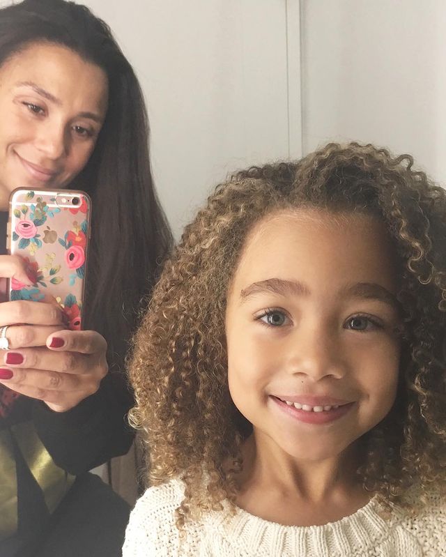 Marilee Fiebig in a black dress with her daughter in a white t-shirt.